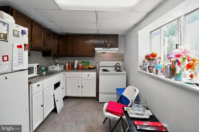 a kitchen with stainless steel appliances kitchen island granite countertop a sink dishwasher and cabinets with wooden floor