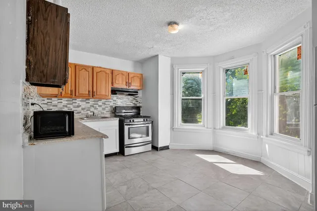 a kitchen with a stove a sink and a microwave