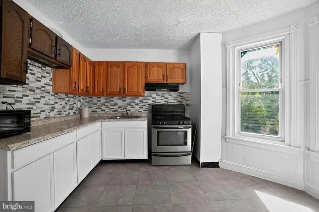 a kitchen with stainless steel appliances granite countertop a stove sink and cabinets