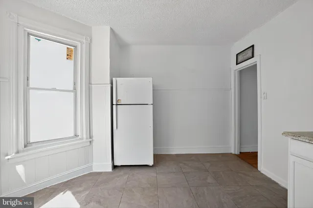 a view of a kitchen with refrigerator and cabinet