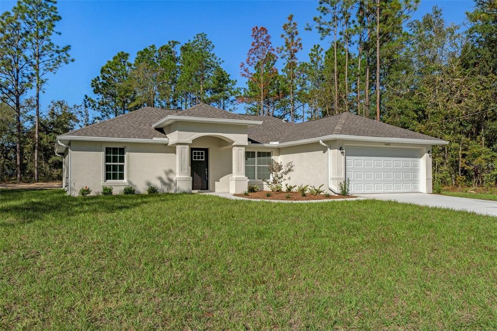 14477 Chimney Swift Road Brooksville, FL 34614 - Photo 1 of 1 a front view of a house with a garden and yard