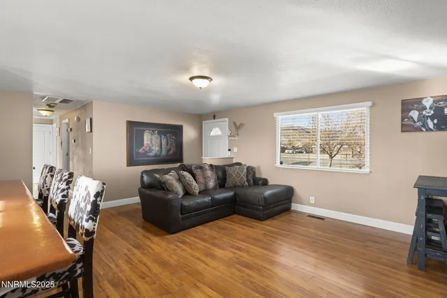 a living room with furniture and a dining table with kitchen view