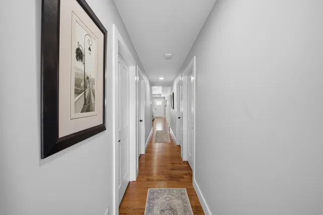 a view of a hallway with wooden floor and closet