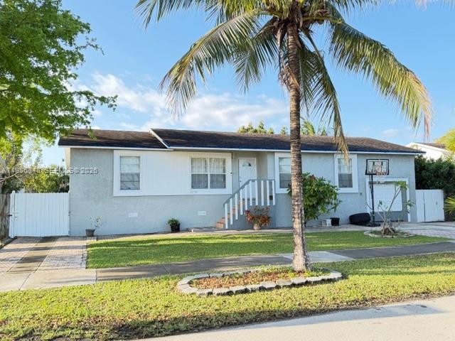 9770 Southwest 210th Street Cutler Bay, FL 33189 - Photo 2 of 32 a front view of a house with a yard table and chairs