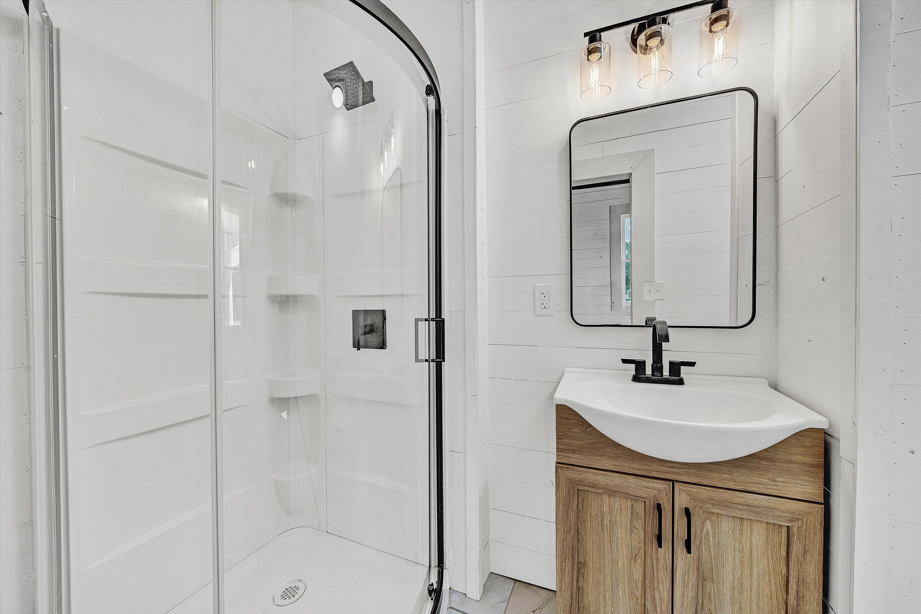 402 7th Street Salem, VA 24153 - Photo 15 of 32 a bathroom with a sink a mirror a vanity and shower