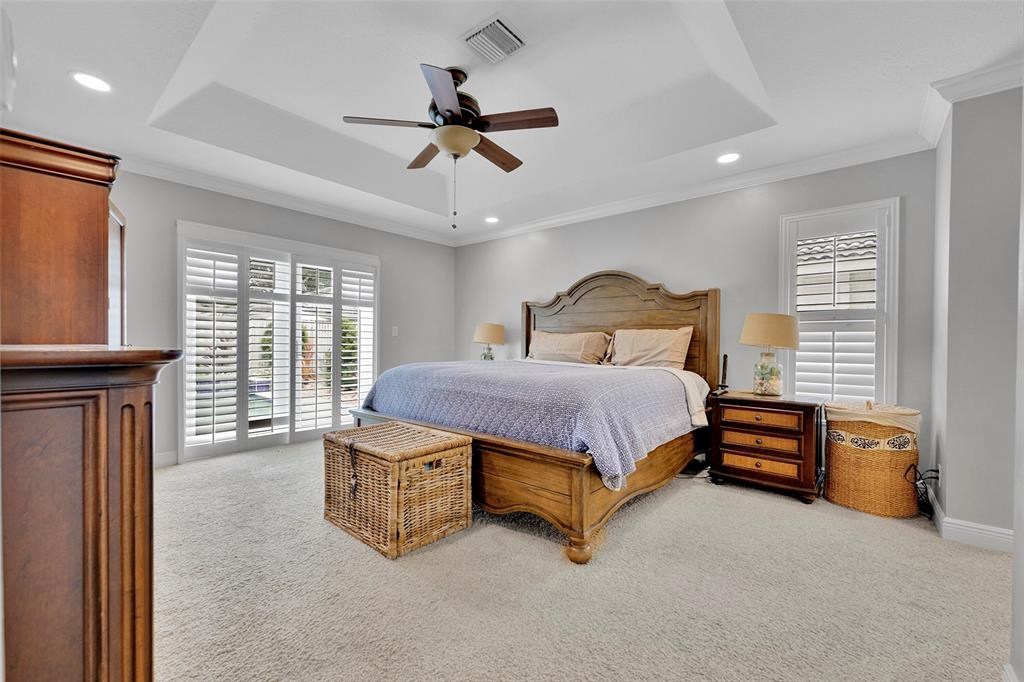 3588 Sahara Springs Boulevard Pompano Beach, FL 33069 - Photo 20 of 41 a spacious bedroom with a bed and a chandelier