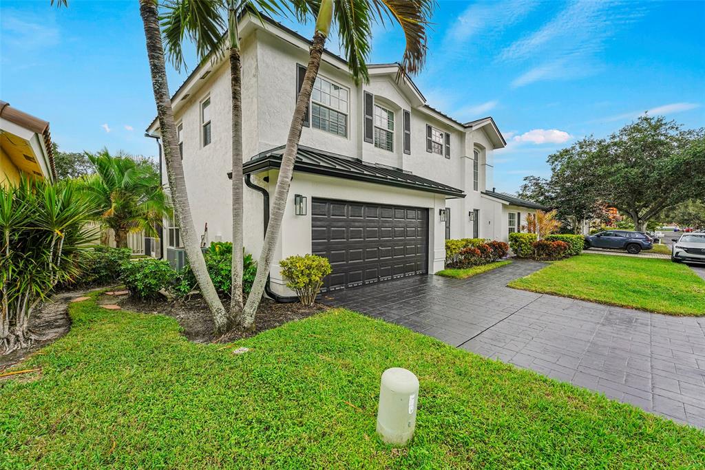 3588 Sahara Springs Boulevard Pompano Beach, FL 33069 - Photo 2 of 41 a front view of a house with a yard