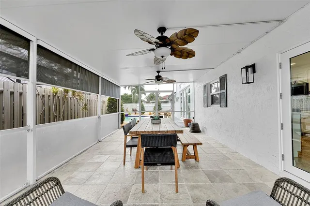 a view of a white house with a yard and potted plants