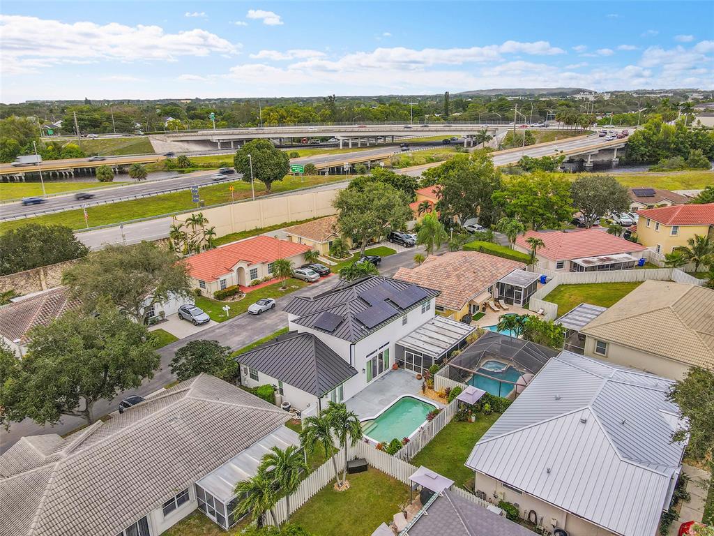 3588 Sahara Springs Boulevard Pompano Beach, FL 33069 - Photo 34 of 41 an aerial view of a city with lots of residential buildings and mountain view in back