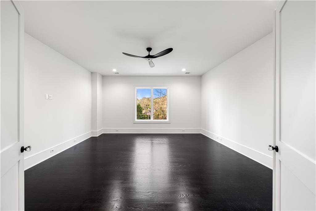 5211 Powers Ferry Road Northwest Sandy Springs, GA 30327 - Photo 91 of 106 an empty room with wooden floor ceiling fan and windows