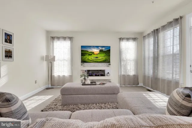 a living room with furniture a flat screen tv and a large window