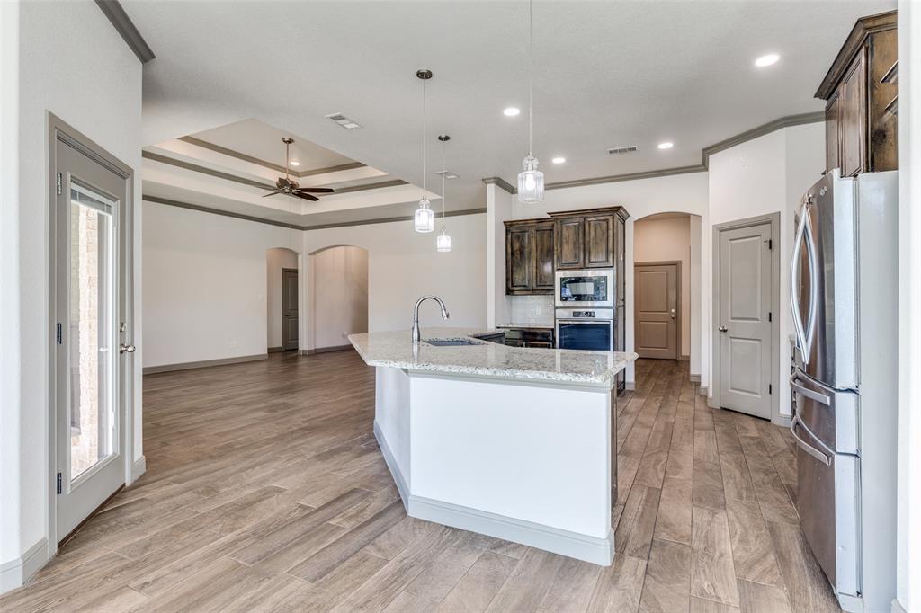 1029 Sunflower Paradise, TX 76073 - Photo 13 of 38 a kitchen with stainless steel appliances granite countertop a refrigerator and a stove top oven
