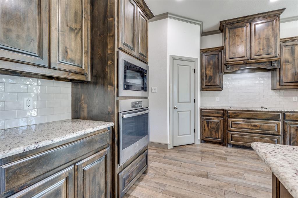 1029 Sunflower Paradise, TX 76073 - Photo 14 of 38 a kitchen with stainless steel appliances granite countertop a refrigerator microwave and stove