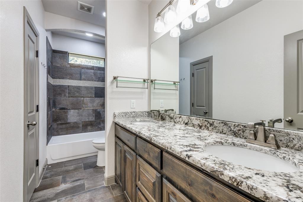 1029 Sunflower Paradise, TX 76073 - Photo 25 of 38 a bathroom with a granite countertop sink a toilet and bathtub