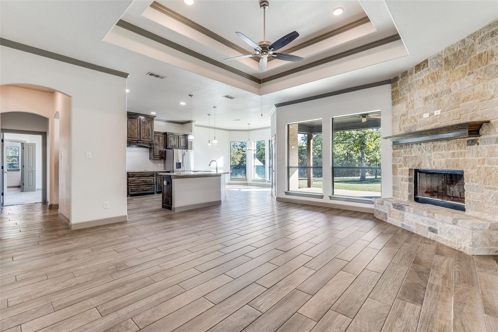 1029 Sunflower Paradise, TX 76073 - Photo 9 of 38 a view of a livingroom with a fireplace a ceiling fan wooden floor and windows