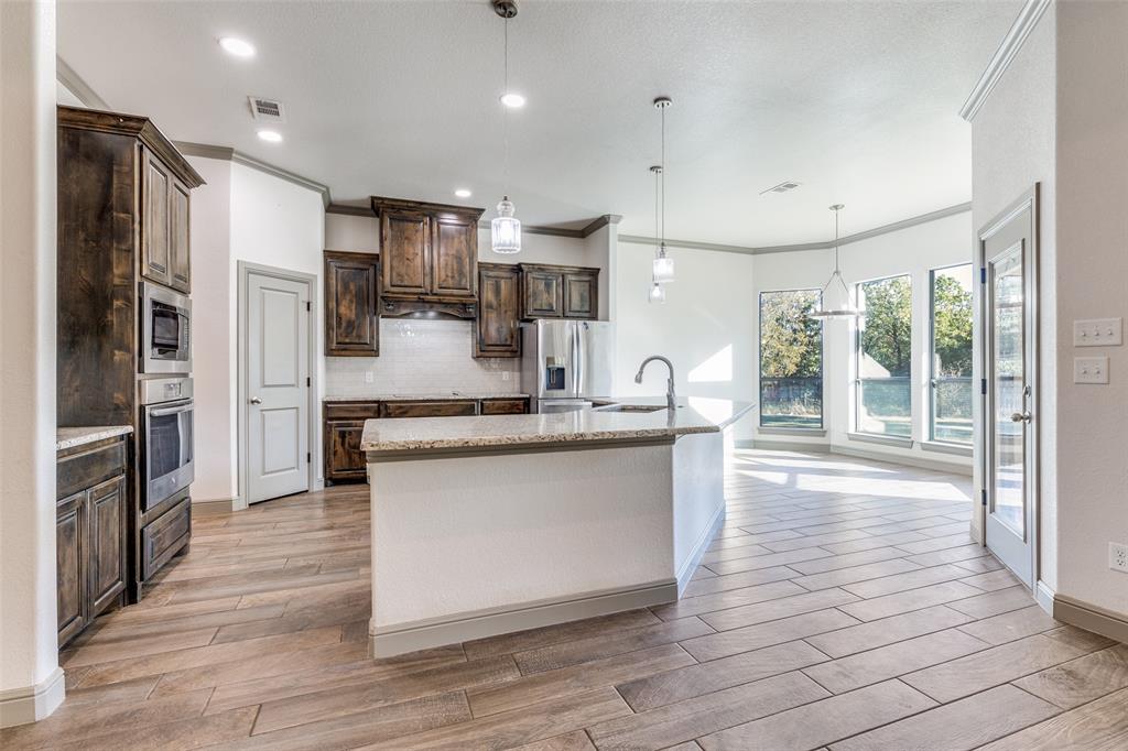 1029 Sunflower Paradise, TX 76073 - Photo 10 of 38 a kitchen with stainless steel appliances granite countertop a refrigerator and a stove top oven