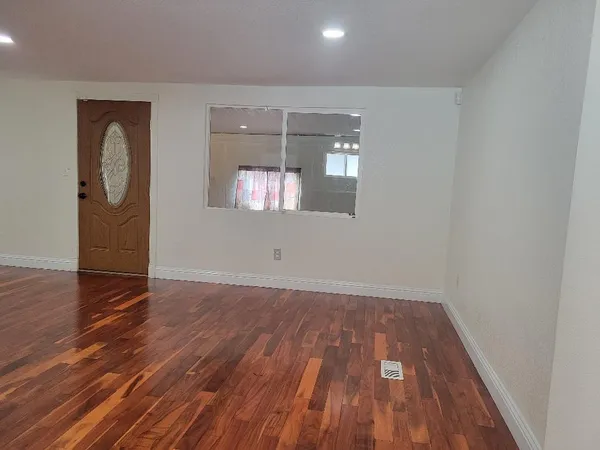 a kitchen with a sink a refrigerator and wooden floor