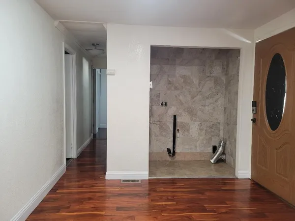 a view of kitchen with cabinets wooden floor and stainless steel appliances