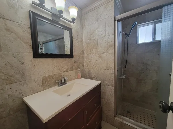 a bathroom with a granite countertop sink toilet and shower
