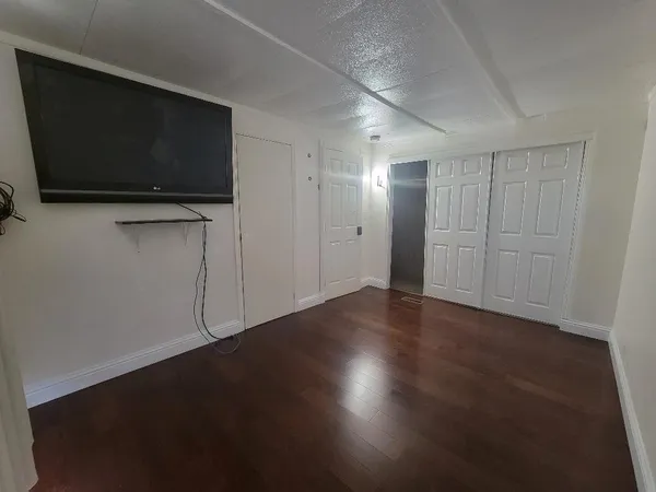 a view of empty room with wooden floor