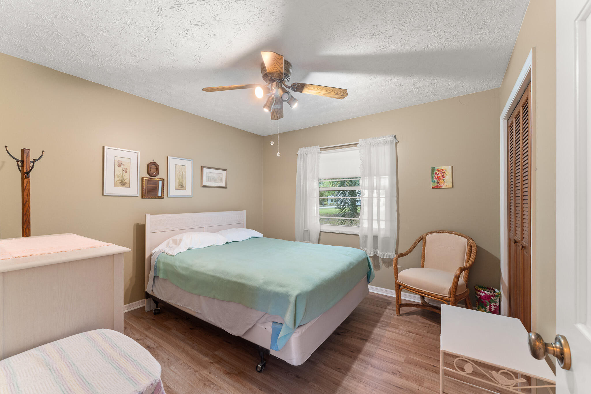 1653 Southwest 85th Terrace Stuart, FL 34997 - Photo 34 of 54 a bedroom with a bed a chandelier and a window