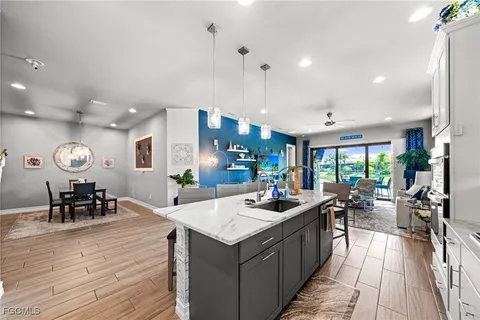a kitchen with a stove a refrigerator and a dining table with wooden floor