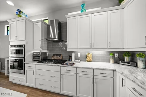 a kitchen with stainless steel appliances granite countertop a sink a stove and cabinets