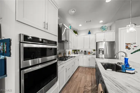 a kitchen with stainless steel appliances a stove sink microwave and cabinets