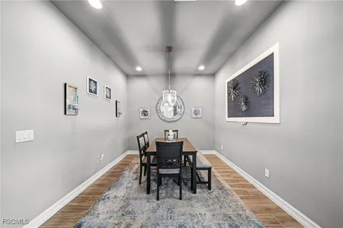 a dining room with wooden floor and a chandelier