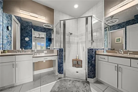a bathroom with a granite countertop sink a mirror and shower