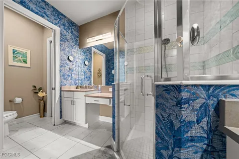 a bathroom with a granite countertop sink a toilet and shower