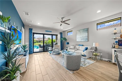 a living room with furniture floor to ceiling window and potted plant