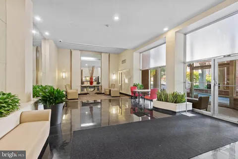 a lobby with furniture and potted plants