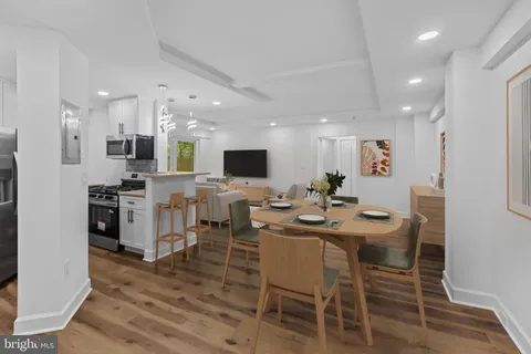 a kitchen with stainless steel appliances kitchen island granite countertop a dining table and chairs