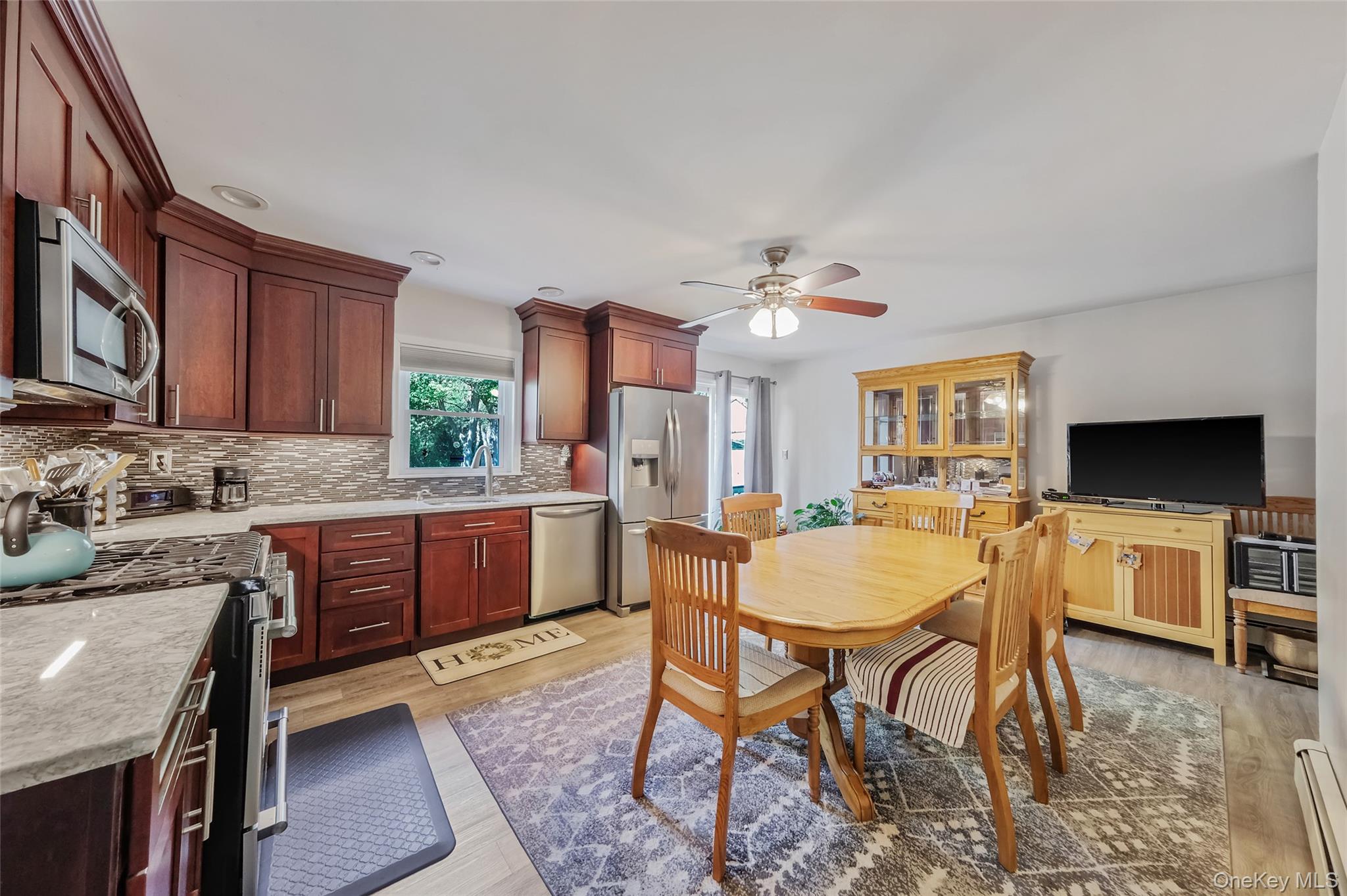 59 Maybrook Road North Babylon, NY 11703 - Photo 27 of 43 a kitchen with stainless steel appliances granite countertop a stove a sink dishwasher a dining table and chairs with wooden floor