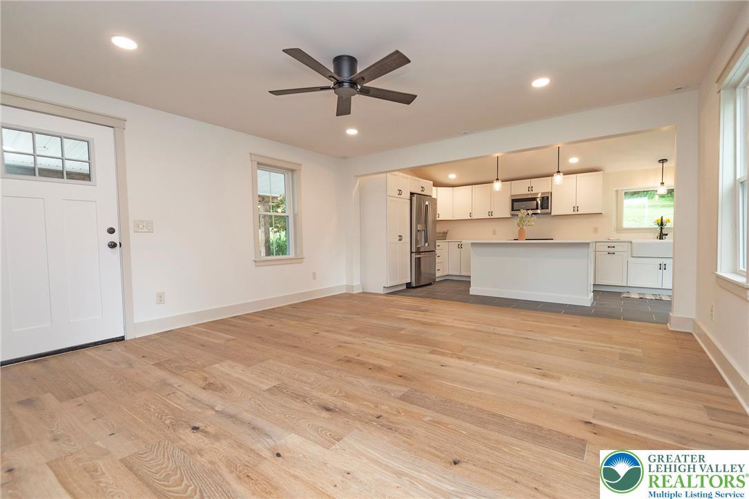 72 Allegheny Road Mount Bethel, PA 18343 - Photo 6 of 72 An open-concept interior features light hardwood floors leading to a modern kitchen with a spacious island.