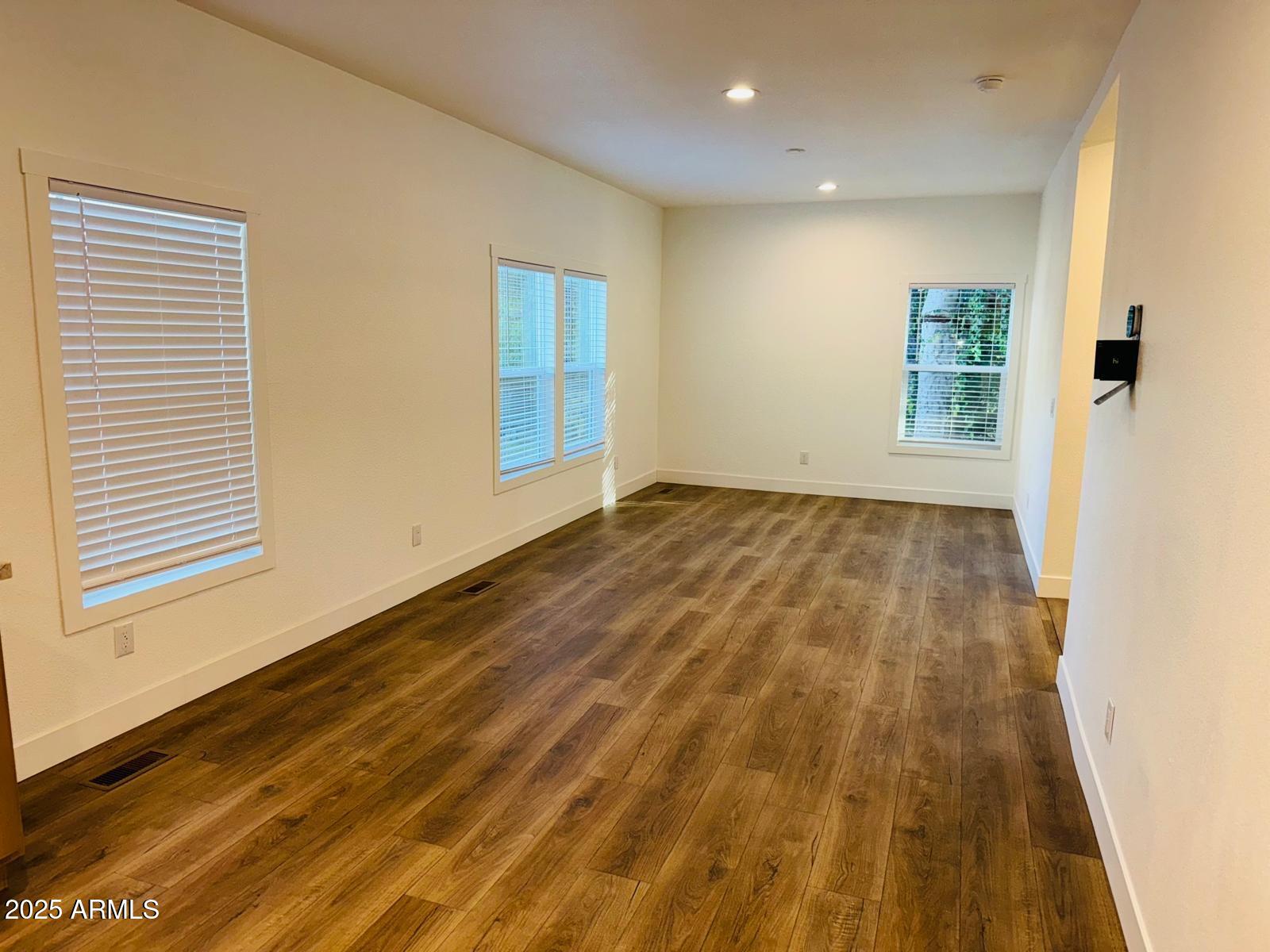4035 East Goldmine Road Rimrock, AZ 86335 - Photo 11 of 40 a view of an empty room with wooden floor and a window
