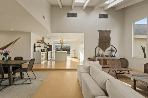 a living room with furniture a flat screen tv and kitchen view