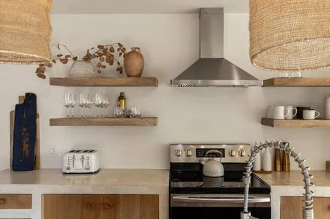 a dining hall with stainless steel appliances granite countertop a stove and a sink