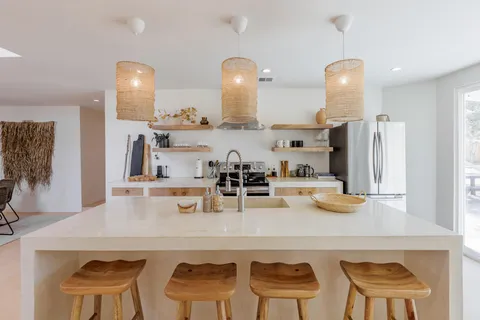 a kitchen with a dining table chairs and cabinets
