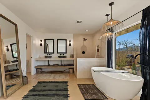 a bathroom with a tub a double vanity sink and mirror