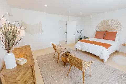 a bedroom with furniture and a large window