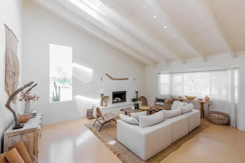 a living room with furniture a chandelier and a fireplace