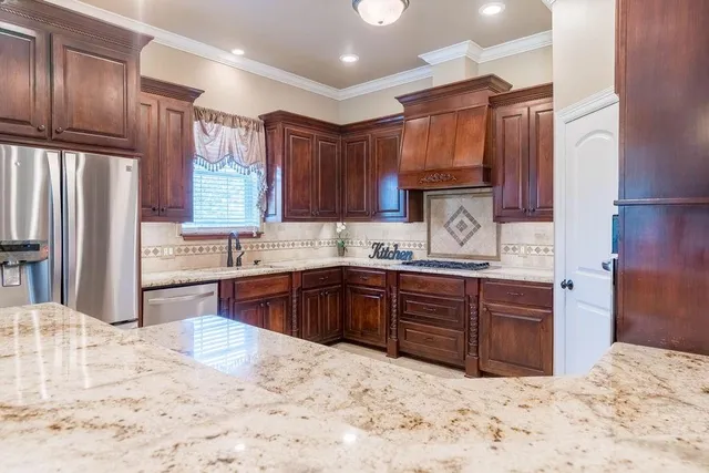 a kitchen with stainless steel appliances kitchen island granite countertop a sink and cabinets