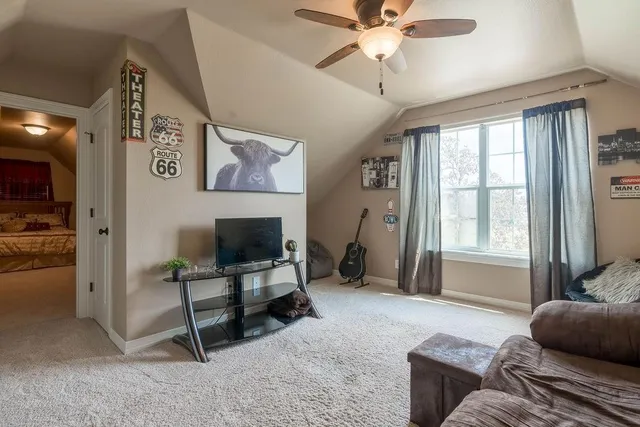 a living room with furniture and a ceiling fan