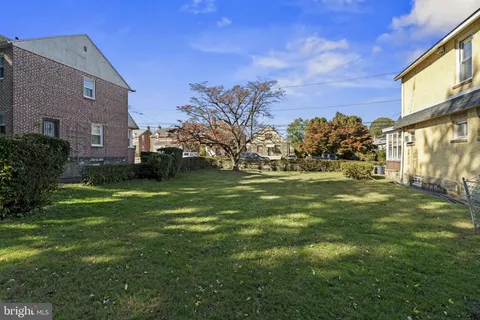 a backyard of a house with plants and large trees