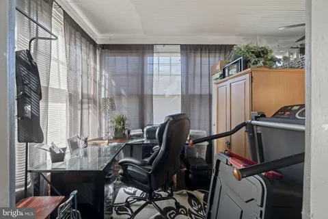 a view of a workspace with furniture and a window