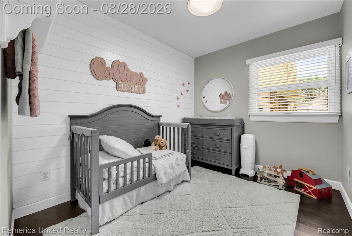 3687 Van Amberg Road Brighton, MI 48114 - Photo 27 of 56 White shiplap accent wall, dark wood-finish flooring, recessed ceiling light, window with blinds, and painted gray walls