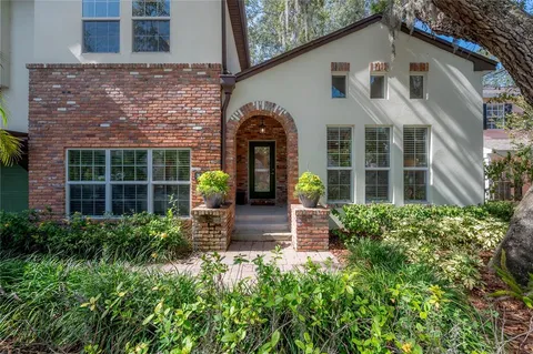 an open kitchen with kitchen island a stove a sink a refrigerator and white cabinets with wooden floor