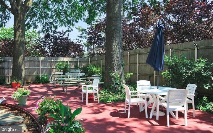 220 Locust Street, Unit 26AS Philadelphia, PA 19106 - Photo 5 of 9 a view of a patio with table and chairs potted plants and large tree